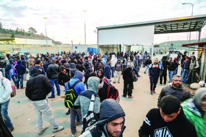 פועלים פלסטינים במחסום // צילום: אלכס ליבק, 'הארץ'